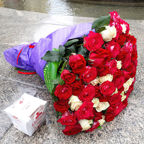 Большой букет красно-белых роз и конфеты фото